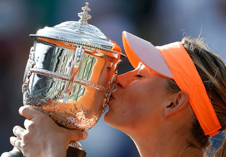 Maria Sharapova of Russia kisses the trophy as she poses during the ceremony after defeating Simona Halep of Romania during their women's singles final match to win the French Open tennis tournament at the Roland Garros stadium in Paris June 7, 2014. (REUTERS)