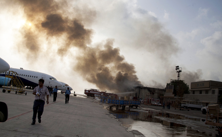 Smoke rises above Karachi airport terminal Monday, June 9, 2014 in Pakistan. Gunmen disguised as police guards attacked the terminal with machine guns and a rocket launcher during a five-hour siege that killed 13 people as explosions echoed into the night, while security forces retaliated and killed all the attackers, officials said Monday. (AP)