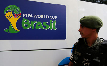 A Brazilian policeman looks at a sign on a bus to be used by South Korea's national soccer team, in front of the hotel where the team will set up its training camp when they arrive for the 2014 World Cup, in Foz do Iguacu, June 10, 2014. (REUTERS)