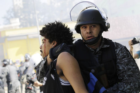 A protester is detained by police during a demonstration demanding better public services and protesting the money spent on the World Cup in Sao Paulo, Brazil, Thursday, June 12, 2014. (AP)