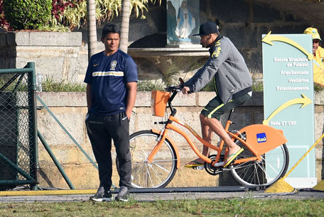 Brazil's forward Neymar rides a bicycle ahead of a training session at the Granja Comary training complex in Teresopolis during the 2014 FIFA World Cup football tournament on July 1, 2014. (AFP)