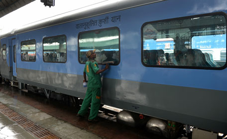 An Indian railways worker cleans a coach prior to the trial run of a high-speed train between New Delhi and Agra is flagged off at New Delhi railway station on July 3, 2014. (AFP)
