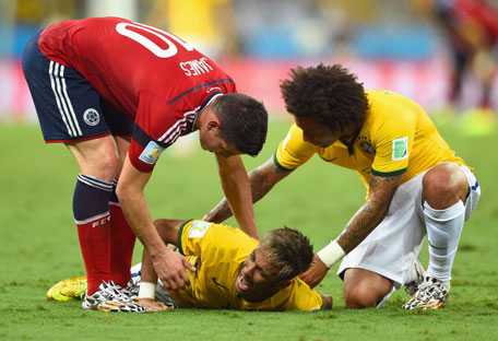 Neymar of Brazil lies on the field after a challenge as teammate Marcelo and James Rodriguez of Colombia look on during the 2014 FIFA World Cup Brazil Quarter Final match between Brazil and Colombia at Castelao on July 4, 2014 in Fortaleza, Brazil. (GETTY)