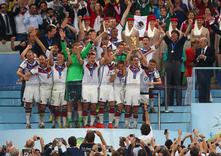 Philipp Lahm of Germany lifts the World Cup trophy with teammates after defeating Argentina 1-0 in extra time as FIFA President Joseph S. Blatter and German Chancellor Angela Merkel look on during the 2014 FIFA World Cup Brazil Final match between Germany and Argentina at Maracana on July 13, 2014 in Rio de Janeiro, Brazil. (GETTY)