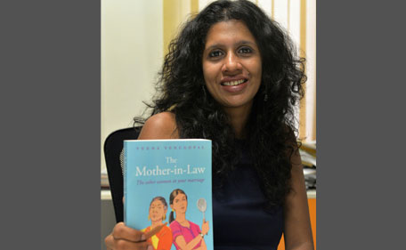Indian writer Veena Venugopal poses with her book 'The Mother-in-Law' at her home in New Delhi. (AFP)