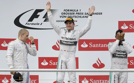 Mercedes driver Nico Rosberg (centre) of Germany, Williams driver Valtteri Bottas (left) of Finland and Mercedes driver Lewis Hamilton of Britain react on the podium after the German Formula One Grand Prix in Hockenheim, Germany, Sunday, July 20, 2014. (AP)