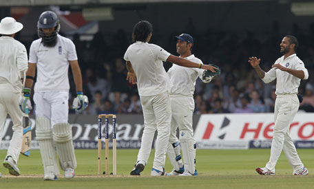 India’s Ishant Sharma  celebrates with India’s captain and wicketkeeper MS Dhoni after taking the wicket of England’s Moeen Ali on the fifth day of the second Test between England and India at Lord's cricket ground in London on July 21, 2014. (AFP)