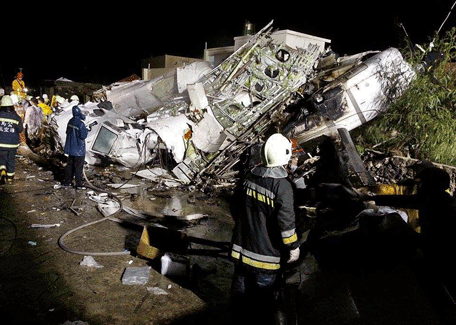 Rescue workers survey the wreckage of TransAsia Airways flight GE222 which crashed while attempting to land in stormy weather on the Taiwanese island of Penghu, late Wednesday, July 23, 2014. A plane landing in stormy weather crashed outside an airport on a small Taiwanese island late Wednesday, and a transport minister said dozens of people were trapped and feared dead. (AP)