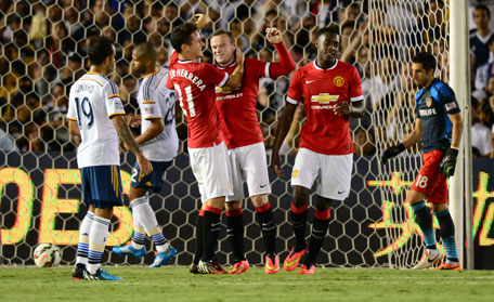 Manchester United's Wayne Rooney (centre) is congratulated by teammates Ander Herrera (left) and Danny Welbeck after scoring from the penalty spot to give his side a 2-0 lead against the LA Galaxy at halftime during their Chevrolet Cup match at the Rose Bowl in Pasadena, California on July 23, 2014. (AFP)