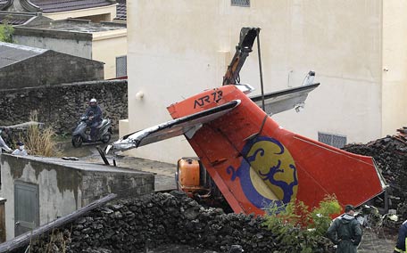 Soldiers remove the wreckage of a TransAsia Airways turboprop plane that crashed on the rooftop, on Taiwan's offshore island Penghu. (REUTERS)