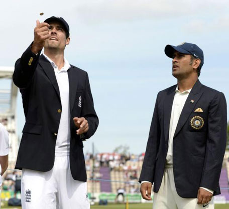 England's captain Alastair Cook tosses the coin as India's captain Mahendra Singh Dhoni watches before the third Test match at the Rose Bowl cricket ground, Southampton, England July 27, 2014. (REUTERS)
