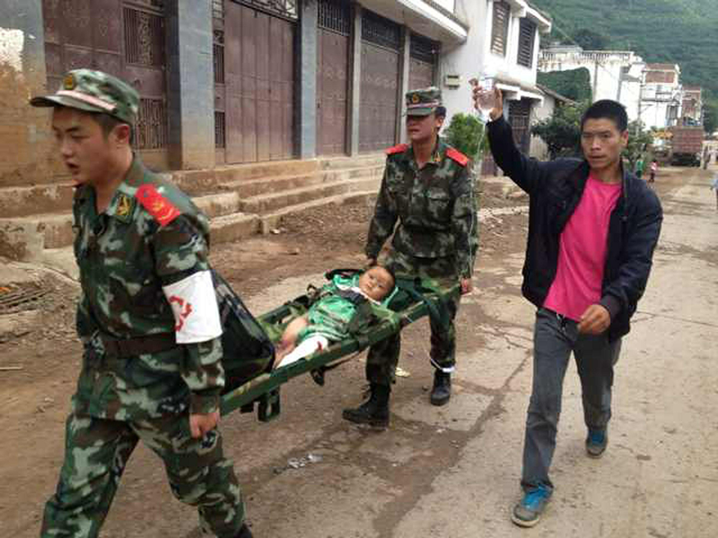 Rescuers carry an injured child on a stretcher after a 6.1 magnitude earthquake hit the area in Ludian county in Zhaotong, southwest China's Yunnan province on August 3, 2014.  (AFP)