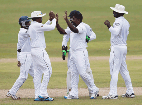 Sri Lanka's Rangana Herath (C) celebrates with teammates after taking the wicket of Pakistan's Asad Shafiq (not pictured) during the second day of their first test cricket match in Galle August 7, 2014. (REUTERS)