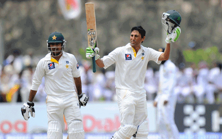 Pakistan cricketer Younis Khan (R) raises his bat and helmet in celebration after scoring 150 runs as teammate Sarfraz Ahmed looks on during the second day of the opening Test match between Sri Lanka and Pakistan at the Galle International Cricket Stadium in Galle on August 7, 2014.  AFP