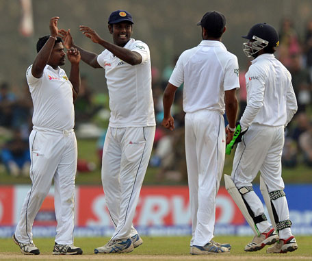 Sri Lanka's Rangana Herath (left) celebrates after dismissing Pakistan's Khurram Manzoor on the fourth day of the 1st Test at Galle International Cricket Stadium on Aug 9, 2014. (AFP)