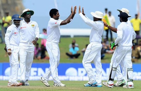 Sri Lankan cricketer Dhammika Prasad (third left) celebrates with teammates after dismissing unseen Pakistan batsman Saeed Ajmal during the final day of the opening Test match between Sri Lanka and Pakistan at the Galle International Cricket Stadium in Galle on August 10, 2014. (AFP)