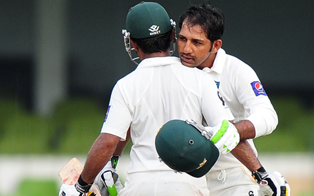 Pakistan cricketer Sarfraz Ahmed (R) is congratulated by his teammate Asad Shafiq (L) after scoring a half-century (50 runs) during the second day of the second Test match between Sri Lanka and Pakistan at the Sinhalese Sports Club (SSC) Ground in Colombo on August 15, 2014. (AFP)