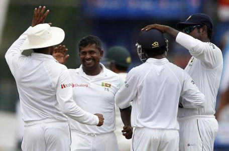 Sri Lanka's Rangana Herath (centre) celebrates with captain Angelo Mathews (right) and teammates after taking the wicket of Pakistan's Sarfraz Ahmed (not pictured) during the third day of their second and final Test in Colombo August 16, 2014. (REUTERS)