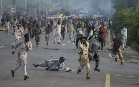 Anti-government protesters run after police personnel during the Revolution March in Islamabad September 1, 2014. Pakistan is preparing to launch a selective crackdown against anti-government protesters trying to bring down the government of Prime Minister Nawaz Sharif, the defense minister said, warning demonstrators against storming government buildings. (REUTERS)