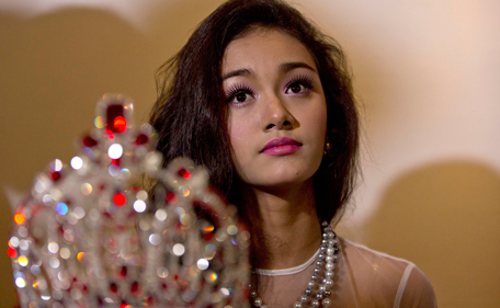 May Myat Noe, Myanmar's first international beauty queen, winner of the 2014 Miss Asia Pacific World, sits with her crown that she allegedly ran away with, during a press conference in Yangon, Myanmar Tuesday, Sept. 2, 2014. (AP)