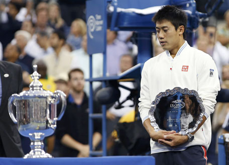 Kei Nishikori of Japan holds his runner up trophy as he looks at the winner's trophy after being defeated in the men's singles final match by Marin Cilic of Croatia at the 2014 US Open tennis tournament in New York, September 8, 2014. (REUTERS)