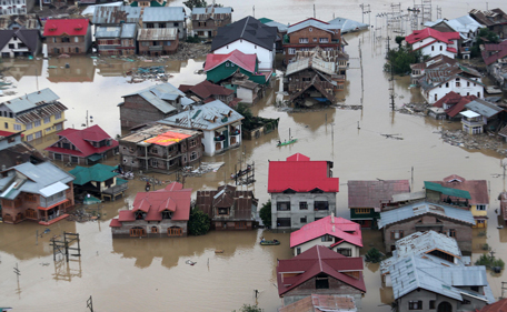 Flood-affected people row boats past partially submerged buildings in floodwaters in Srinagar, India, Tuesday, Sept. 9, 2014. The death toll from floods in Pakistan and India reached 400 on Tuesday and have put more than half a million people in peril and rendered thousands homeless in the two neighboring states. (AP)