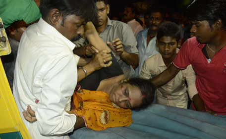 An injured woman is lifted onto a stretcher following a stampede as people celebrated the Dussehra festival, in Patna, in Bihar state, on October 3, 2014. A stampede at the popular religious festival in eastern India left 32 people dead and several dozen injured, an official said. (AFP)