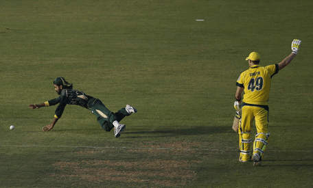 Pakistani bowler Fawad Alam dives for the ball as Australian Steven Smith (R) gestures during the first One Day International (ODI) cricket match  in Sharjah on October 7, 2014.    AFP