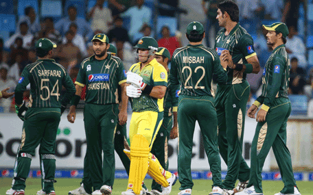 Australian batsman Aaron Finch (C) walks off the pitch after being caught out while Pakistani players celebrate during their second One Day International cricket match in Dubai on October 10, 2014. AFP