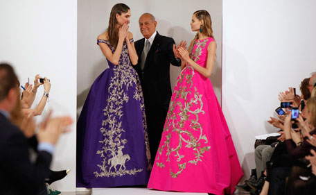 Designer Oscar De La Renta (C) smiles with model Karlie Kloss (L) and another model after presenting his Autumn/Winter 2013 collection during New York Fashion Week in this February 12, 2013 file photo. Oscar De La Renta, one of the biggest names in the fashion industry over the last half century, has died at the age of 82, a family member told ABC News on October 20, 2014. (REUTERS)