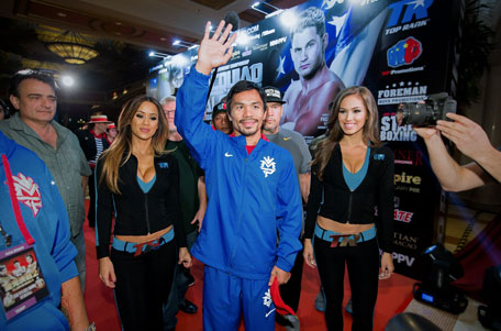 This handout picture taken on November 18, 2014 and released by Passionmarketing shows Philippine boxing icon Manny Pacquiao waving after arriving in Macau ahead of his next fight against US boxer Chris Algieri on November 23. (AFP)