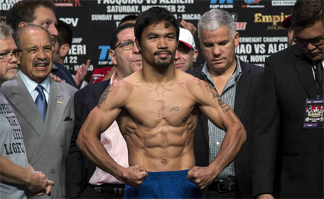 Manny Pacquiao poses on the scales during an official weigh-in for his World Boxing Organisation (WBO) 12-round welterweight title fight against Chris Algieri at the Venetian Macao hotel in Macau November 22, 2014. (Reuters)
