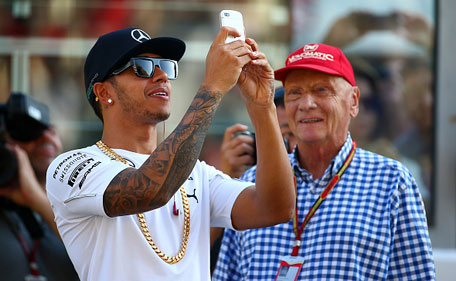 Niki Lauda, non-executive chairman of Mercedes GP watches as Lewis Hamilton of Great Britain and Mercedes GP takes a photo of the crowd before the Abu Dhabi Formula One Grand Prix at Yas Marina Circuit on November 23, 2014 in Abu Dhabi, United Arab Emirates. (Getty)