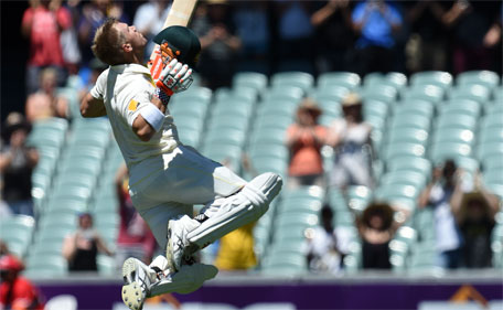 Australia's batsman David Warner celebrates as he reaches his century on the first day of the the first Test between Australia and India at Adelaide Oval in Adelaide on December 9, 2014. (AFP)