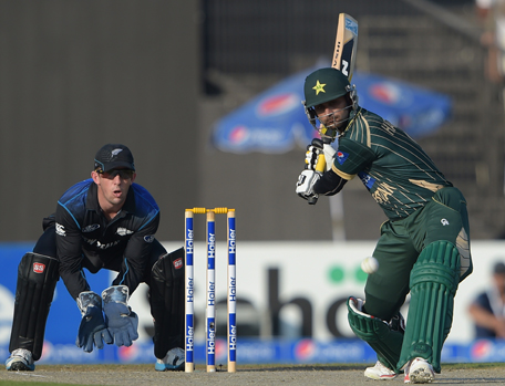 Pakistani batsman Mohammad Hafeez (R) eyes the ball before playing a shot as New Zealand wicketkeeper Luke Ronchi looks on during the second Day-Night International cricket match between Pakistan and New Zealand at the Sharjah cricket stadium in Sharjah on December 12, 2014. Pakistan captain Misbah-ul Haq won the toss and decided to bat in the second day-night international against New Zealand in Sharjah. AFP