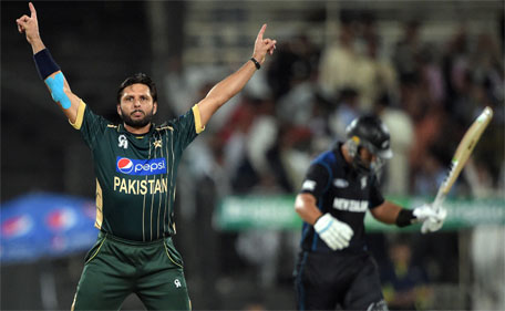 Pakistani captain and spinner Shahid Afridi (left) celebrates after taking the wicket of New Zealand batsman Ross Taylor during the third one-day international between Pakistan and New Zealand at the Sharjah cricket stadium in Sharjah on December 14, 2014. (AFP)