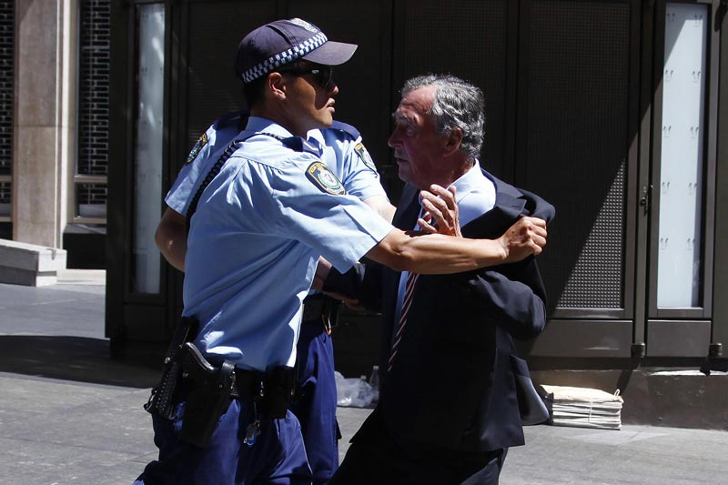 Police push back a member of the public who tried to get into a building located near the Lindt cafe, where hostages are being held, at Martin Place in central Sydney December 15, 2014. (Reuters)