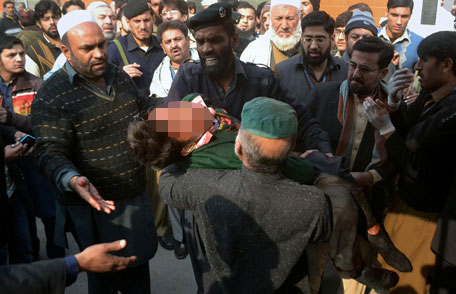 Hospital security guards carry a students injured in the shootout at a school under attacked by Taliban gunmen in Peshawar, Pakistan,Tuesday, Dec 16, 2014.  (AP)