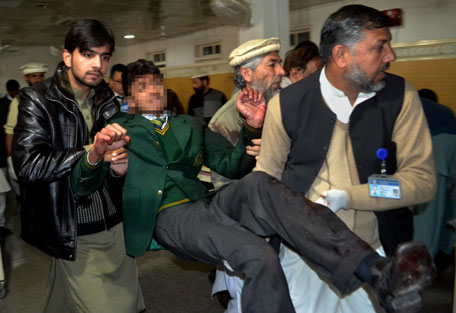 Pakistani volunteers carry a student injured in the shootout at a school under attack by Taliban gunmen, at a local hospital in Peshawar, Pakistan,Tuesday, Dec. 16, 2014. (AP)