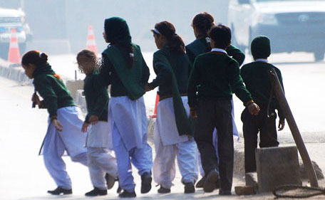 Schoolchildren cross a road as they move away from a military run school that is under attack by Taliban gunmen in Peshawar, December 16, 2014. Taliban gunmen in Pakistan took hundreds of students and teachers hostage on Tuesday in a school in the northwestern city of Peshawar, military officials said. (Reuters)