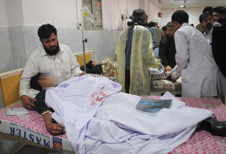 A man comforts his son, who was injured during an attack by Taliban gunmen on the Army Public School, at Lady Reading Hospital in Peshawar, December 16, 2014. Taliban gunmen in Pakistan took hundreds of students and teachers hostage on Tuesday in a school in the northwestern city of Peshawar, military officials said. REUTERS