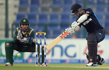New Zealand captain Kane Williamson (R) plays a shot as Pakistani wicketkeeper Sarfraz Ahmed looks on during the fourth day-night international cricket match between Pakistan and New Zealand at the Zayed International Cricket Stadium in Abu Dhabi on December 17, 2014.  New Zealand captain Kane Williamson won the toss and opted to bat in the fourth day-night international against Pakistan in Abu Dhabi.   AFP