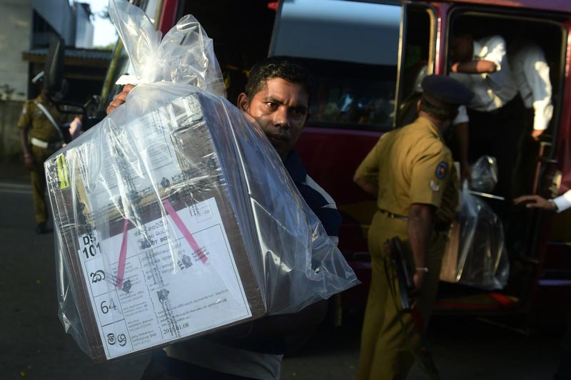 A Sri Lankan poll officer carries a ballot box to be transferred to a main counting centre following the country's presidential election in Colombo on January 8, 2015.  (AFP)