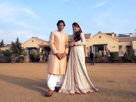 In this handout photograph released by the Pakistan Tehreek Insaf (PTI) party on January 8, 2015, Pakistani opposition leader Imran Khan (L) and new wife Reham Khan pose for a photograph during their wedding ceremony at his house in Islamabad. Pakistani opposition leader Imran Khan wed a TV journalist in a simple ceremony at his Islamabad home January 8, ending years of speculation surrounding the former playboy cricketer widely considered his country's most eligible man. (AFP)
