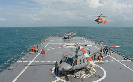 An Indonesian rescue helicopter (R) flies as the Indonesian Navy conduct operations to lift the tail of AirAsia QZ8501 in the Java Sea on January 9, 2015. Ping signals from the black box data recorders of crashed AirAsia Flight QZ8501 were detected on January 9, a senior Indonesian search official told AFP. (AFP)