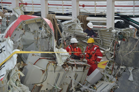 Indonesian crew of the Crest Onyx ship prepare to unload recovered wreckage of AirAsia flight QZ8501 at port in Kumai on January 11, 2015. Indonesian divers on January 11 found the crucial black box flight recorders of the Air Asia plane that crashed in the Java Sea a fortnight ago with 162 people aboard, the transport ministry said. (AFP)