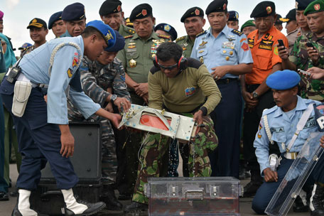 Indonesian officers move the FDR (Flight Data Recorder) (C) of the AirAsia flight QZ8501 into a suitable protective transportation case in Pangkalan Bun after it was retrieved from the Java Sea on January 12, 2015. (AFP)