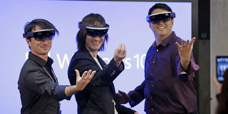 Microsoft's Joe Belfiore, from left, Alex Kipman, and Terry Myerson playfully pose for a photo while wearing 'Hololens' devices following an event demonstrating new features of Windows 10 at the company's headquarters on Wednesday, Jan. 21, 2015, in Redmond, Wash. (AP)