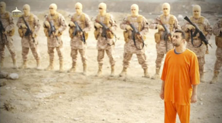 A man purported to be Daesh captive Jordanian pilot Muath al-Kasaesbeh (in orange jumpsuit) stands in front of armed men in this still image from an undated video filmed from an undisclosed location made available on social media on February 3, 2015. (Reuters)