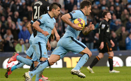Manchester City's Argentinian striker Sergio Aguero (second left) and Manchester City's Argentinian defender Martin Demichelis (right) run back with the ball after Manchester City's English midfielder James Milner's goal during the English Premier League football match between Manchester City and Hull City at the The Etihad Stadium in Manchester, England, on February 7, 2015. (AFP)